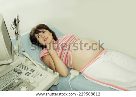 Ultrasound examination of of the pregnant woman, pregnant woman on reception at the doctor...
