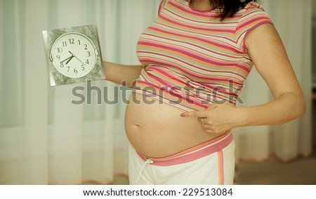 Pregnant woman with clock. Pregnant woman\'s belly