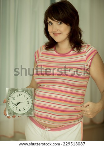 Pregnant woman with clock. Pregnant woman\'s belly