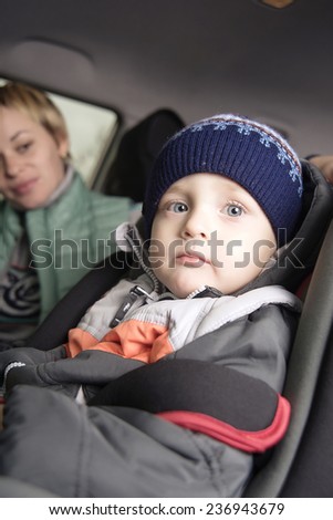 little boy in a a car seat, family in the car