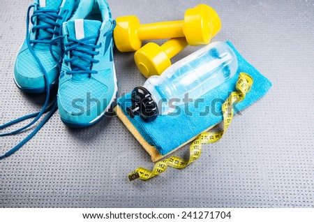 Sneakers and dumbbells fitness on a gray background. Different tools for sport