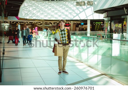 young man with shopping bags, man in shop with bags and a bouquet of tulips
