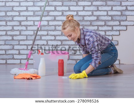 beautiful girl washes the floors in the apartment