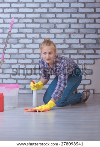 beautiful girl washes the floors in the apartment