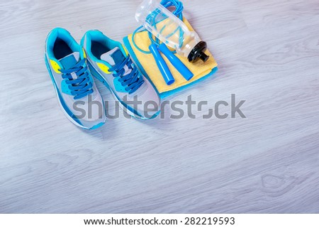 sneakers and a jump rope on a gray background.  Different tools for sport
