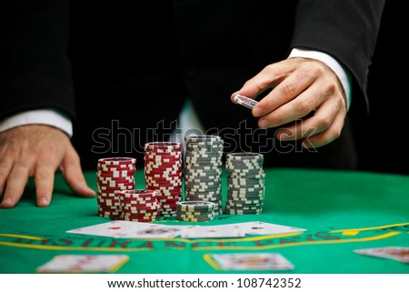 blackjack in a casino, a man makes a bet, and puts a chip