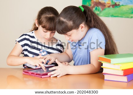 Two cute little girls is drawing with felt-tip pen in preschool