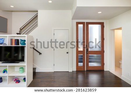 Entrance in modern home with open floor plan and modern glass wood entry door.