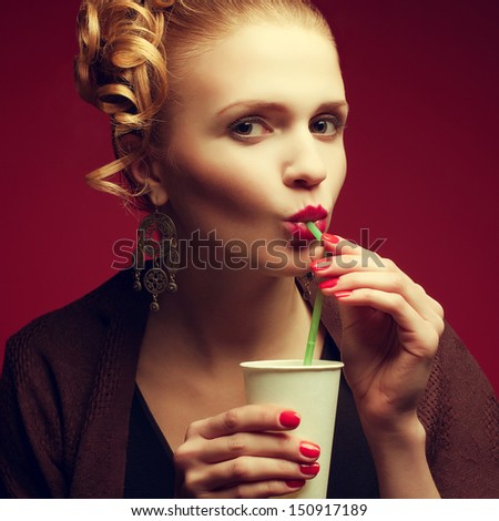 Coffee-break concept. Portrait of a glamorous movie star drinking her cold tea (water, juice, soda, beverage) after work. Perfect hair, make-up and manicure. Close up. Studio shot
