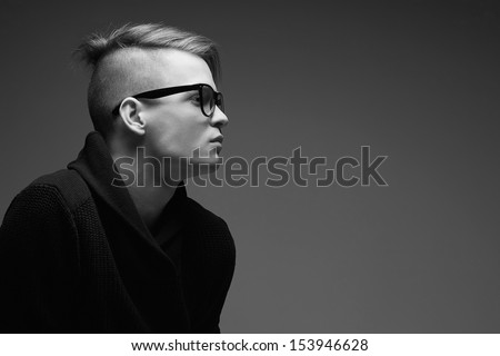 Male Beauty Concept. Portrait Of A Fashionable Young Man With Stylish Haircut Wearing Trendy Glasses And Sweater &Amp; Posing Over Gray Background. Perfect Hair &Amp; Skin. Hipster Style. Close Up. Copy-Space