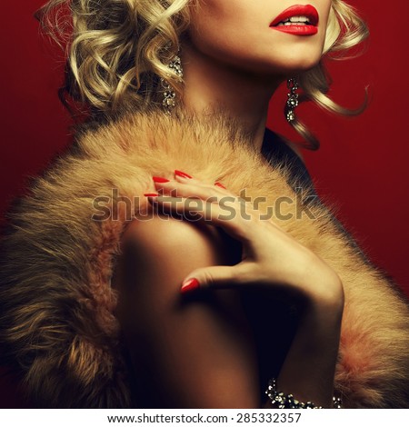 Girl\'s best friends and femme fatale concept. Marilyn Monroe style. Portrait of rich young woman wearing expensive luxurious diamond accessories, furs. Studio shot