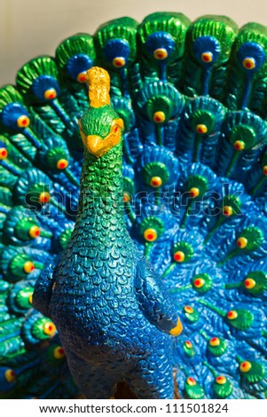 Colorful peacock statue of lime plaster to be adorned with sacred things in the house.