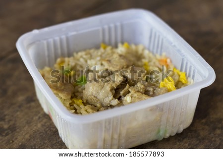 Thai Fast food in a plastic box, fried rice on wood table