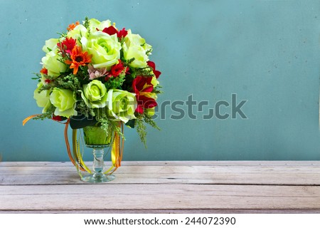 flower bouquet in glass vase on wood table grunge wall