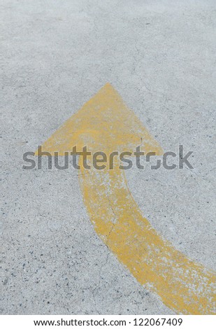 Yellow arrow symbol on the cement floor background