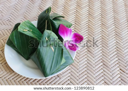 Thai dessert wrapped in banana leaves on plate