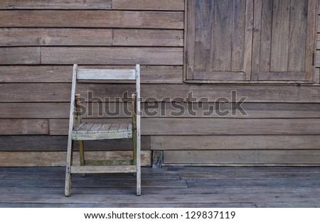 Old wooden chair against wooden wall