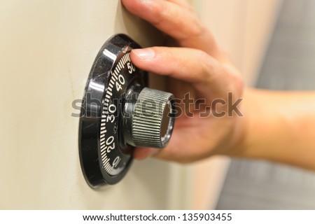 Hand opening a safe.
