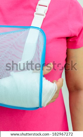 Hand injury with white medicine bandage wearing hand sling