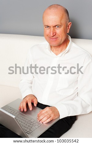 smiley senior man searching something in internet