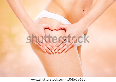beautiful feminine hip and hands like heart over blurred background