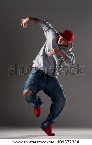 full length picture of dancing man over dark background
