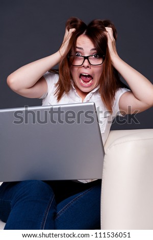 stressed student with laptop sitting on sofa