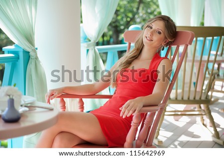 alluring young woman sitting on the chair and looking at camera. shot in the cafe