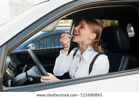 modern woman sitting in the car and painting her laps