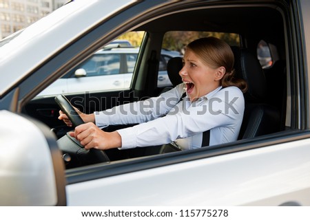 frightened woman sitting in the car and holding for the wheel