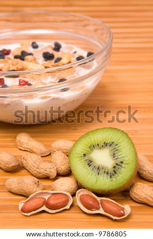 Still life picture of kiwi, peanuts and muesli in portrait orientation