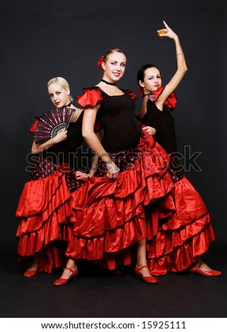 three dancers in spanish dresses over dark background