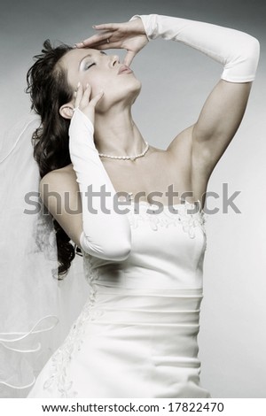 stock photo attractive woman in wedding dress posing against grey 