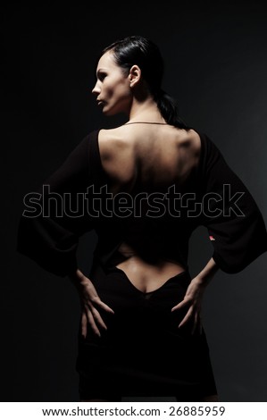 glamor woman in dress with naked back over black background