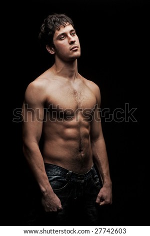 stock photo handsome man with naked torso against black background