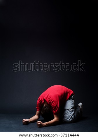 desperate man praying  in darkness