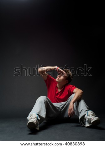 young man sitting on the floor and looking at something