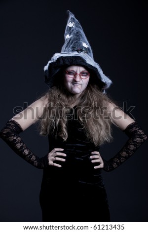 portrait of sly witch over dark background. halloween theme