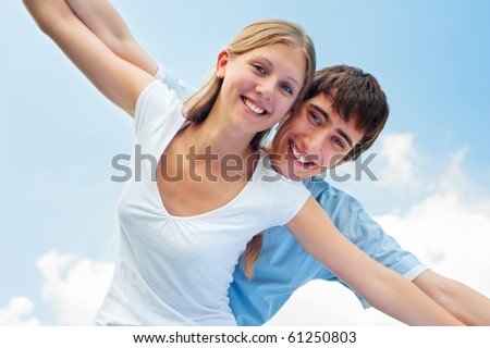 portrait of cheerful couple in love over blue sky