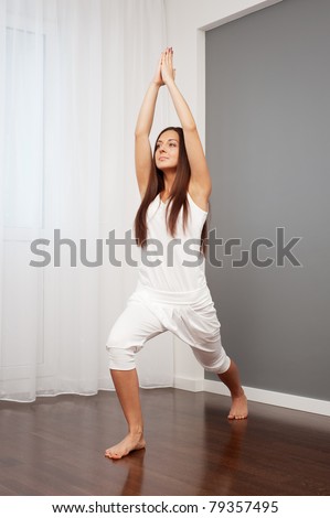 portrait of young woman practicing yoga in room