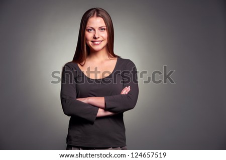 portrait of happy smiley woman with folded hands over dark grey background