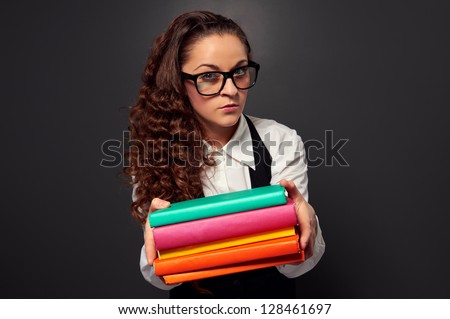 young teacher in glasses offering books. picture over dark background