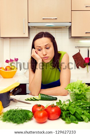 weary housewife standing in kitchen