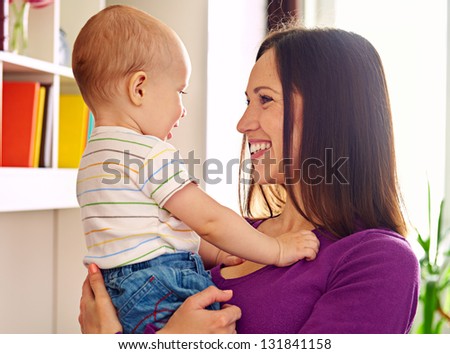 smiley mother looking at adorable son