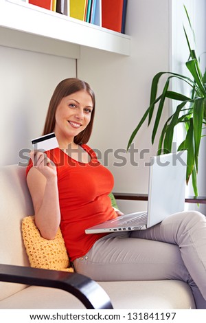 beautiful young woman shopping with laptop and credit card