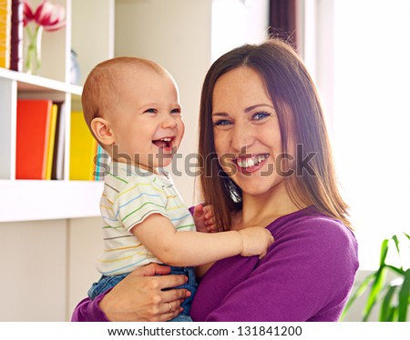 young smiley mother and adorable son at home