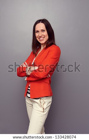 happy sexy woman with folded hands posing over dark background. studio shot