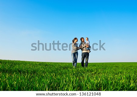 Lively Photo Of Happy And Smiley Family Walking At The Field