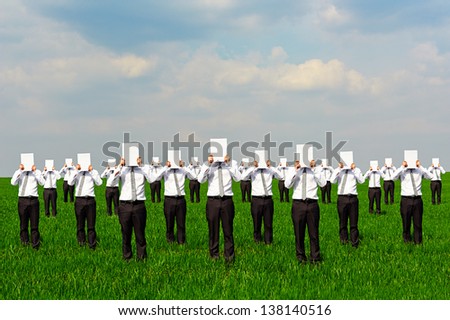 crowd of businessmen with white empty posters. concept photo on green field