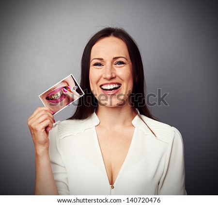 healthy happy woman holding picture with dirty yellow teeth